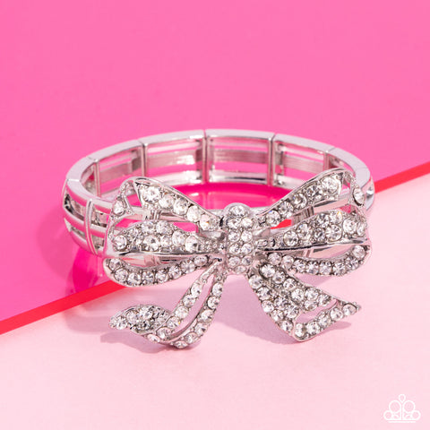 IT'S ALL A-BOW-TO ME - WHITE RHINESTONE SILVER BOW STRETCH BRACELET - PAPARAZZI - LIFE OF THE PARTY MAY 2024