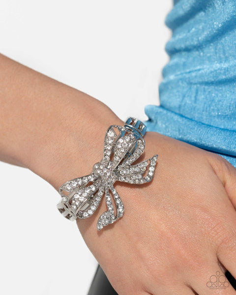 IT'S ALL A-BOW-TO ME - WHITE RHINESTONE SILVER BOW STRETCH BRACELET - PAPARAZZI - LIFE OF THE PARTY MAY 2024